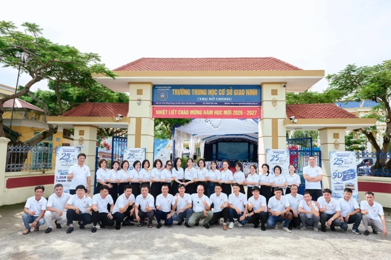 Áo kỷ niệm 25 năm ra trường THCS Giao Phong – Tập thể cựu học sinh niên khóa 1997–2001 mặc áo polo trắng kỷ niệm 25 năm ra trường, chụp trước cổng THCS Giao Phong. – 1