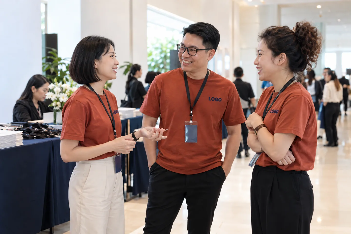 Nhân viên mặc áo sự kiện cam đất in chữ LOGO tại hội nghị