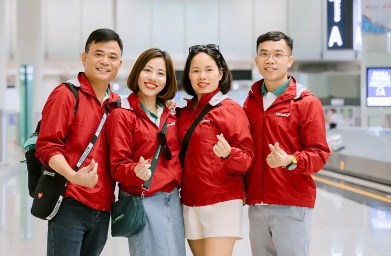 Nhóm khách hàng sử dụng áo khoác gió Herbalife khi di chuyển qua sân bay.